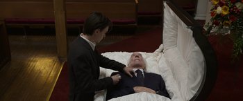 Movie still from “Mr. Harrigan's Phone” (2022), directed by John Lee Hancock – A man in a suit and tie is standing next to an older man in a suit; Medium shot, High angle