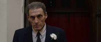 Movie still from “Mr. Harrigan's Phone” (2022), directed by John Lee Hancock – An older man wearing a suit and tie with a flower in his lapel; Close Up shot, Low angle