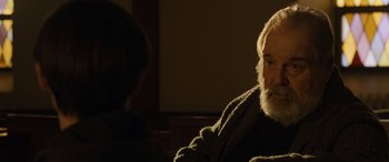 Movie still from “Mr. Harrigan's Phone” (2022), directed by John Lee Hancock – An older man sitting in a chair in front of a younger man; Close Up shot, Over the shoulder angle