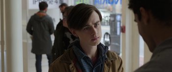 Movie still from “Mr. Harrigan's Phone” (2022), directed by John Lee Hancock – A young man in a brown jacket looking to his left; Close Up shot, Over the shoulder angle