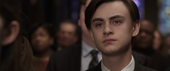 Movie still from “Mr. Harrigan's Phone” (2022), directed by John Lee Hancock – A person wearing a suit and tie; Close Up shot, Over the shoulder angle