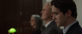 Movie still from “Mr. Harrigan's Phone” (2022), directed by John Lee Hancock – A man and a woman and a man in a suit; Close Up shot, Low angle