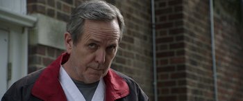 Movie still from “Mr. Harrigan's Phone” (2022), directed by John Lee Hancock – An older man wearing a red and black jacket; Close Up shot, Low angle
