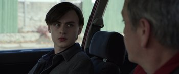 Movie still from “Mr. Harrigan's Phone” (2022), directed by John Lee Hancock – A man sitting in the back seat of a car; Close Up shot, Over the shoulder angle