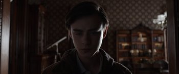Movie still from “Mr. Harrigan's Phone” (2022), directed by John Lee Hancock – A young man is looking down at his face; Close Up shot, Low angle