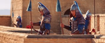 Movie still from “Mulan” (2020), directed by Niki Caro – A couple of men in armor and helmets holding brooms; Medium shot, Low angle