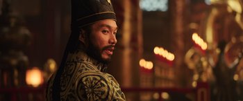 Movie still from “Mulan” (2020), directed by Niki Caro – A man wearing a crown and a robe; Close Up shot, Over the shoulder angle