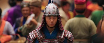 Movie still from “Mulan” (2020), directed by Niki Caro – A man wearing a metal helmet and a suit of armor; Close Up shot, Low angle