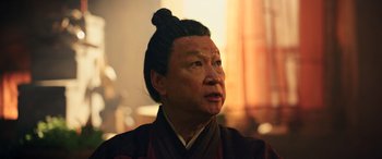 Movie still from “Mulan” (2020), directed by Niki Caro – An older man wearing a traditional chinese outfit; Close Up shot, Low angle