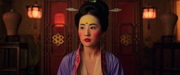 Movie still from “Mulan” (2020), directed by Niki Caro – A woman in a geisha costume with a bow on her head; Close Up shot, Low angle