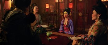 Movie still from “Mulan” (2020), directed by Niki Caro – Two women sitting at a table in front of a mirror; Medium shot, Over the shoulder angle