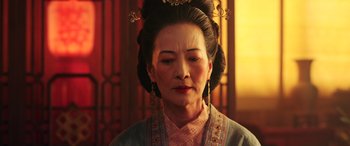Movie still from “Mulan” (2020), directed by Niki Caro – An older woman wearing a traditional chinese dress; Close Up shot, Low angle