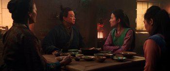 Movie still from “Mulan” (2020), directed by Niki Caro – A man and a woman sitting at a dinner table; Medium shot, Over the shoulder angle