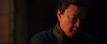 Movie still from “Mulan” (2020), directed by Niki Caro – An older woman is looking down at her face; Close Up shot, Low angle