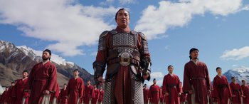Movie still from “Mulan” (2020), directed by Niki Caro – A group of men in red and black costumes; Medium shot, Low angle