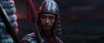 Movie still from “Mulan” (2020), directed by Niki Caro – A man wearing a helmet and holding a broom; Close Up shot, Low angle