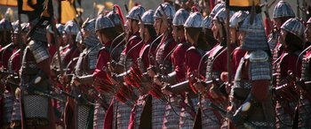 Movie still from “Mulan” (2020), directed by Niki Caro – A group of men in red and black uniforms holding arrows; Wide shot, High angle