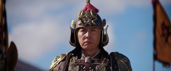 Movie still from “Mulan” (2020), directed by Niki Caro – A man wearing a helmet and a suit of armor; Close Up shot, Low angle