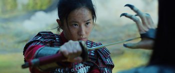 Movie still from “Mulan” (2020), directed by Niki Caro – A young girl dressed as a samurai is holding a bow and arrow; Close Up shot, Low angle