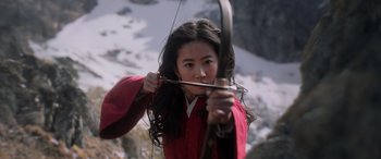 Movie still from “Mulan” (2020), directed by Niki Caro – A young woman is holding a bow and arrow; Medium shot, Low angle