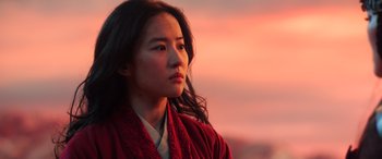 Movie still from “Mulan” (2020), directed by Niki Caro – A woman in a red robe looking off into the distance; Close Up shot, Low angle