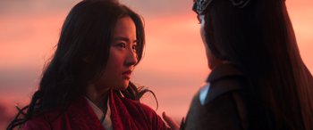 Movie still from “Mulan” (2020), directed by Niki Caro – A woman in a red jacket is talking to another woman; Close Up shot, Over the shoulder angle