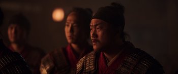 Movie still from “Mulan” (2020), directed by Niki Caro – Two men in traditional asian clothing looking into the distance; Close Up shot, Over the shoulder angle