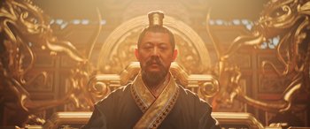 Movie still from “Mulan” (2020), directed by Niki Caro – A man with a long beard and a crown on his head; Close Up shot, Low angle