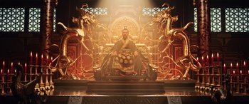 Movie still from “Mulan” (2020), directed by Niki Caro – A man sitting on top of a throne in a room with golden decorations; Wide shot, Low angle