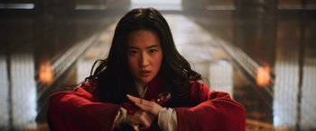 Movie still from “Mulan” (2020), directed by Niki Caro – A woman in a red coat is holding a sword; Close Up shot, Low angle