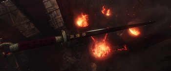 Movie still from “Mulan” (2020), directed by Niki Caro – An image of a sword in the middle of a fire pit; Close Up shot, High angle