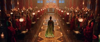Movie still from “Mulan” (2020), directed by Niki Caro – A woman in a green cape standing in front of a group of people; Extreme Wide shot, Over the shoulder angle