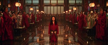 Movie still from “Mulan” (2020), directed by Niki Caro – A woman standing in front of a group of people in a room; Extreme Wide shot, High angle