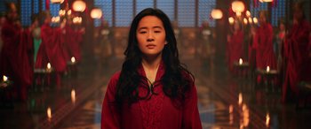 Movie still from “Mulan” (2020), directed by Niki Caro – A woman in a red shirt is looking at the camera; Medium shot, High angle