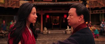 Movie still from “Mulan” (2020), directed by Niki Caro – A man and a woman face to face in front of a building; Close Up shot, Over the shoulder angle
