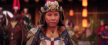 Movie still from “Mulan” (2020), directed by Niki Caro – A man wearing a helmet and a suit of armor; Close Up shot, Low angle