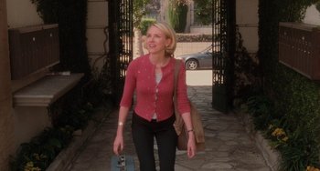 Movie still from “Mulholland Drive” (2001), directed by David Lynch – A woman walking down a street holding a bag; Medium shot, High angle