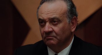 Movie still from “Mulholland Drive” (2001), directed by David Lynch – An older man wearing a suit and tie; Close Up shot, Low angle