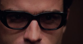 Movie still from “Mulholland Drive” (2001), directed by David Lynch – A man's eyes wearing black glasses; Extreme Close Up shot, Overhead angle
