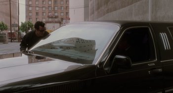 A man standing in front of a parked car