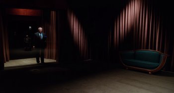Movie still from “Mulholland Drive” (2001), directed by David Lynch – A man standing in front of a window in a dark room; Wide shot, Low angle