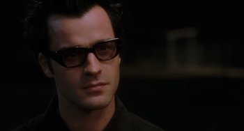Movie still from “Mulholland Drive” (2001), directed by David Lynch – A person wearing glasses; Close Up shot, Over the shoulder angle
