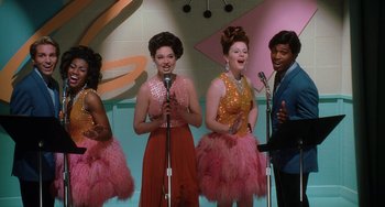 Movie still from “Mulholland Drive” (2001), directed by David Lynch – A group of women singing on a stage with microphones; Medium shot, Low angle