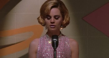 Movie still from “Mulholland Drive” (2001), directed by David Lynch – A woman in a pink dress holding a microphone; Close Up shot, Low angle