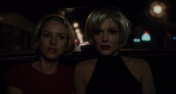 Movie still from “Mulholland Drive” (2001), directed by David Lynch – Two women sitting in the back seat of a car at night; Close Up shot, Over the shoulder angle