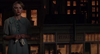 Movie still from “Mulholland Drive” (2001), directed by David Lynch – A woman standing in front of a building with a repair sign; Medium shot, Low angle