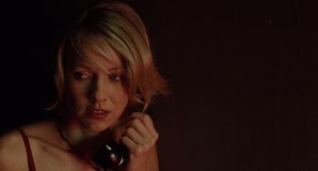 Movie still from “Mulholland Drive” (2001), directed by David Lynch – A beautiful woman holding a cell phone in her hand; Close Up shot, Low angle