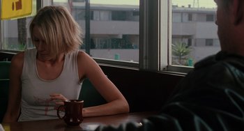 Movie still from “Mulholland Drive” (2001), directed by David Lynch – A woman sitting at a table with a cup of coffee; Medium shot, Over the shoulder angle