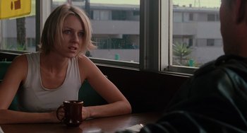 Movie still from “Mulholland Drive” (2001), directed by David Lynch – A woman sitting at a table holding a coffee mug; Close Up shot, Over the shoulder angle