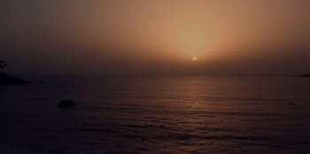 Movie still from “Mumbai Mafia: Police vs the Underworld” (2023), directed by Raaghav Dar – The sun is setting over a body of water; Extreme Wide shot, High angle